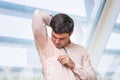 Man with hyperhidrosis sweating under armpit in office Royalty Free Stock Photo