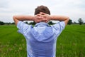 Man with hyperhidrosis sweating very badly under armpit in blue shirt, on grey