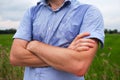 Man with hyperhidrosis sweating very badly under armpit in blue shirt, on grey Royalty Free Stock Photo