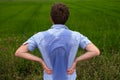 Man with hyperhidrosis sweating very badly under armpit in blue shirt, on grey