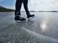 Man ice skating on frozen lake. Thin ice with deeep cracks below man