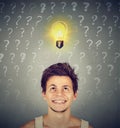 Man with idea light bulb and many questions above head Royalty Free Stock Photo