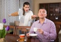 Man ignoring disgruntled wife reprimanding him Royalty Free Stock Photo