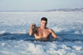 Man immersing in icy water on winter day. Baptism ritual Royalty Free Stock Photo