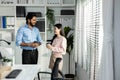 Man indian and asian woman holding coffee cup talking for work relax time standing in modern office. Asian business people meeting Royalty Free Stock Photo