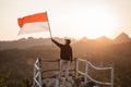 Man with indonesian flag of indonesia on top of the mountain