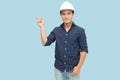 Man industrial engineer wearing a white hard helmet and pointing finger towards something blank copy space.