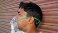 Young Indian man taking Emergency Oxygen with Cannula outside of hospital. Severe causes due to Covid in India concept