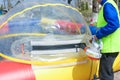 Man inflates a big balloon for the water rides. The injection of