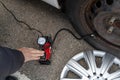 Man inflates tire with air and checking air pressure with gauge pressure in service station. Flat tire concept