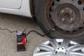 Man inflates tire with air and checking air pressure with gauge pressure in service station. Flat tire concept