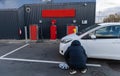 Man inflates tire with air and checking air pressure with gauge pressure in service station. Flat tire concept Royalty Free Stock Photo