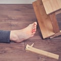 Man injured foot after falling from wooden stepladder. Ladder made of wood broke under a man while working at home Royalty Free Stock Photo