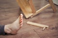 A man injured his toe after falling from a wooden stepladder. Ladder made of wood broke under a man while working at home Royalty Free Stock Photo