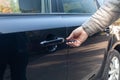 Man inserting car key into the black door lock to open. Close up view Royalty Free Stock Photo