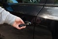 Man inserting car key into the black door lock to open. Close up view Royalty Free Stock Photo