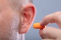 Man Inserting Earplug In His Ear Royalty Free Stock Photo