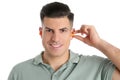 Man inserting foam ear plug on white background Royalty Free Stock Photo