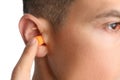 Man inserting foam ear plug on white background, closeup Royalty Free Stock Photo