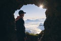 Man inside cave looking at beuatiful landscape