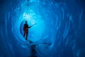 Man inside a melting glacier ice cave. Cut by water from the melting glacier, the cave runs deep into the ice of the Matanuska Royalty Free Stock Photo