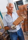 Man inspecting brick for installing wall