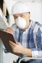 Man inspecting derelict property wearing dust mask