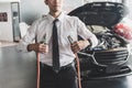 Man inspection holding jumper cables for charger Battery service maintenance of Royalty Free Stock Photo