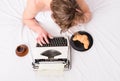 Man inspired lay bedclothes work book. Writer author used old fashioned typewriter. Man with typewriter and coffee lay Royalty Free Stock Photo