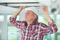 man install suspended ceiling in house Royalty Free Stock Photo