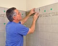 Man installing ceramic tile in bathroom Royalty Free Stock Photo