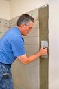 Man installing ceramic tile in bathroom Royalty Free Stock Photo