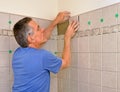 Man installing ceramic tile in bathroom Royalty Free Stock Photo