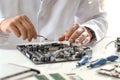 Man installing computer chip onto motherboard at white table, closeup Royalty Free Stock Photo