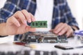 Man installing computer chip onto motherboard at white table, closeup Royalty Free Stock Photo
