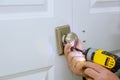 The man is installing the dummy lock of the door by the screwdriver Royalty Free Stock Photo