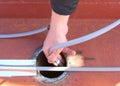 A man is installing gutter deicing, ice-melting, self regulating heating cablesÃ¢â¬Å½ in an industrial rain gutter system