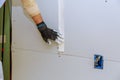 Man installing gypsum plasterboard construction of housing project with drywall installed Royalty Free Stock Photo