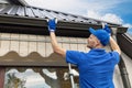 Man installing house roof gutter system Royalty Free Stock Photo