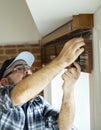 Man installing house window curtain