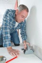 Man installing light laminate flooring in room Royalty Free Stock Photo