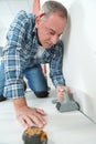 Man installing light laminate flooring in room Royalty Free Stock Photo