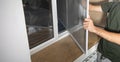 Man installing the mosquito net on the window Royalty Free Stock Photo