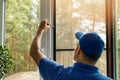 Man installing mosquito net wire screen on house window