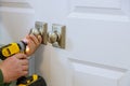 The man is installing the dummy lock of the door by the screwdriver Royalty Free Stock Photo