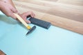 Man Installing New Laminate Wood Flooring. Worker Installing wooden laminate flooring with hammer. Handyman laying down laminate Royalty Free Stock Photo