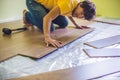 Man installing new wooden laminate flooring. infrared floor heat Royalty Free Stock Photo