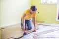 Man installing new wooden laminate flooring. infrared floor heat Royalty Free Stock Photo