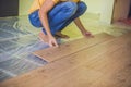 Man installing new wooden laminate flooring. infrared floor heat Royalty Free Stock Photo