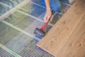 Man installing new wooden laminate flooring. infrared floor heat Royalty Free Stock Photo